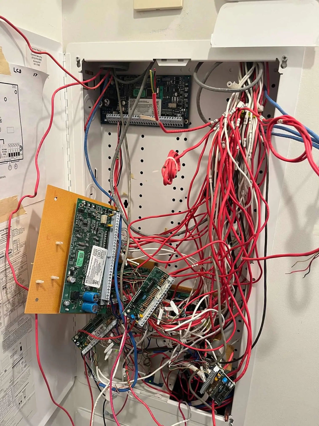 Technician upgrading a DSC PowerSeries panel to a DSC PowerSeries NEO with labeled zone wires and new keypad in an Austin home.